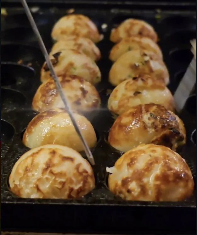 Takoyakis dorándose en la plancha durante su preparación en Atsui Yaki